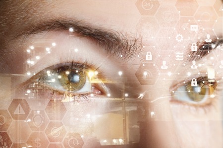 A closeup of a human female eyes with comb cyber security system structure. The concept of data and digital protection and security.の写真素材