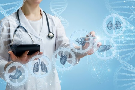 The doctor works with a complicated mechanism of human health on a blue background.の写真素材