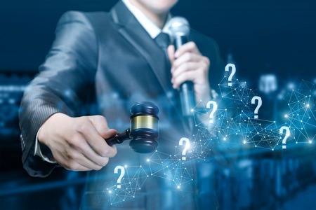 Questions and answers during the auction. An auctioneer with a gavel and a microphone on blurred background.の写真素材