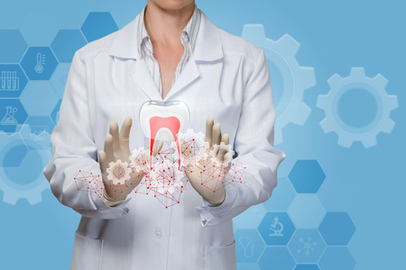 Doctor treats tooth on a blue background.の写真素材