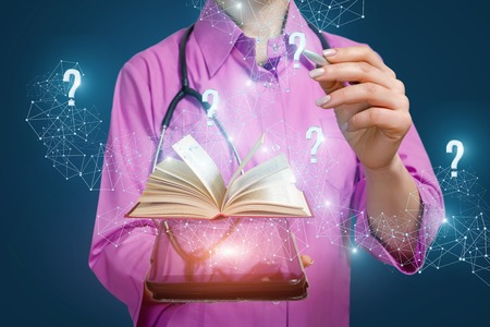 The doctor is looking for answers to questions in textbooks online on a blue background.の写真素材