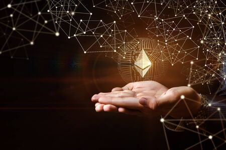 Hands of businessman support ethereum on a dark background.の写真素材