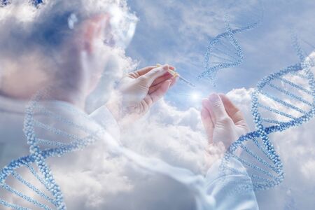 Concept of DNA testing. The hand doctor with the eyedropper on the background of DNA molecules.の写真素材