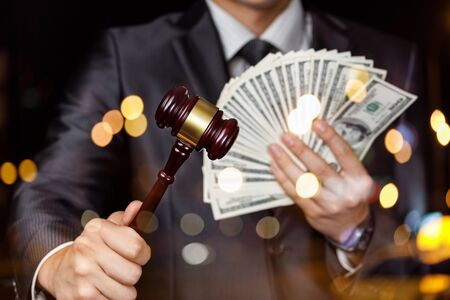 The concept of earning money on the auction house. The auctioneer with cash dollars in hand.の写真素材