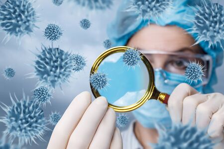 The concept study of the virus. The doctor looks for viruses with a magnifying glass.の写真素材