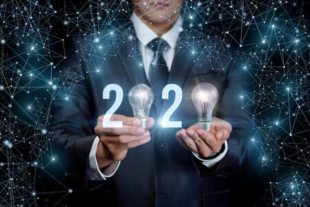 The concept of a new 2020 business year. Businessman showing 2020 on blurred background.の写真素材