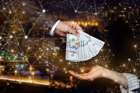 The concept of cash payment means. The hand passes the pack with dollars on the background of the...