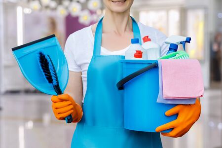 The cleaning lady standing with a bucket and with tool on blurred background.の写真素材