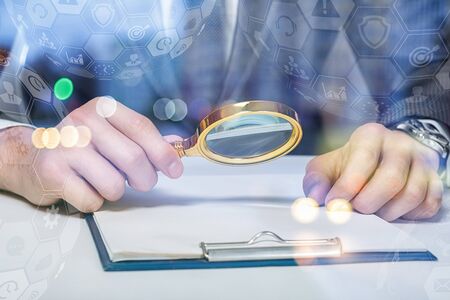 A lawyer or a businessman examining a document with a magnifying glass.