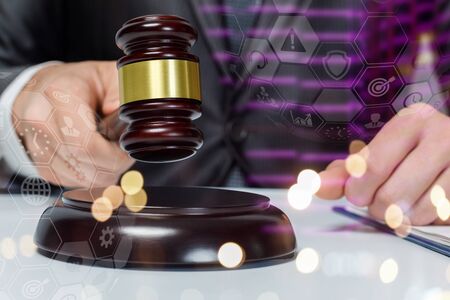 Concept of a legal decision. A lawyer with a hammer on the background of night city.の写真素材