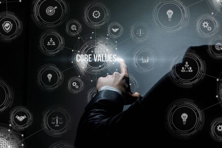 Businessman works with core values in business on a dark background.