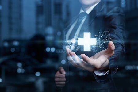 Hand of a businessman offer positive thing represented by plus sign on a blue background.の写真素材