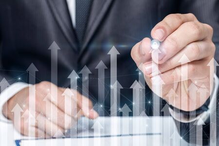 The concept of growth and success in business. Businessman draws arrows growth.