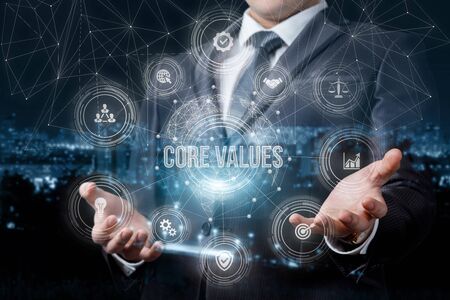 Businessman showing a structure of core values in business on blurred background.