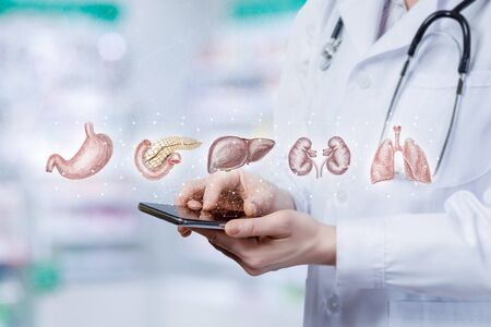 On the virtual screen the phone shows the internal organs on the patient.の写真素材