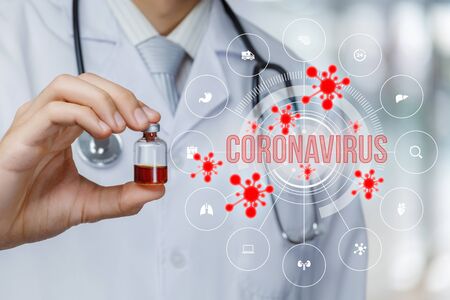 The concept of medication for coronavirus.Doctor holds a tube with medicine and the inscription coronavirus on a blurred background.の写真素材
