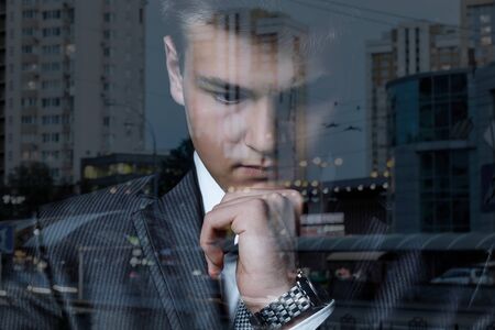 Concept of analytics and brainstorming business. Young businessman thinks on a blurred background.の写真素材