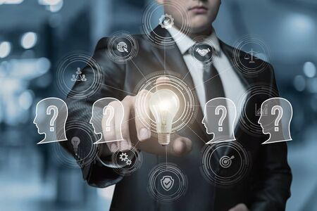 Concept of an idea for solving business problems. Businessman clicks on a burning light bulb.の写真素材