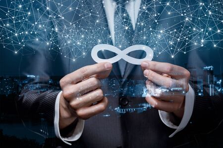 The concept of unlimited traffic on the Internet. Businessman holds an infinity sign on a city...