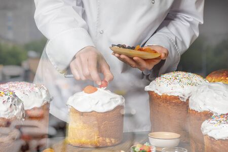 A cook decorates pastries in the dining room in the kitchen.