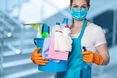 Cleaning lady with tool in cleaning in mask on a blurred background.の写真素材
