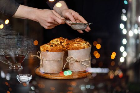 The cook decorates cakes baked on a dark background.の写真素材