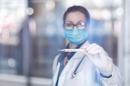 The concept of high fever of the patient.Doctor shows a thermometer with fever.の写真素材