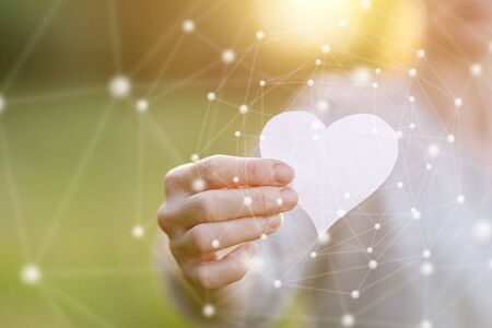 The concept of love on the Internet.Hand shows a heart on a network background.の写真素材