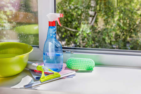 Cleaning products and tools on a window sill.の写真素材