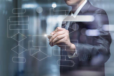 Businessman draws a flowchart of the program on a virtual screen.の写真素材