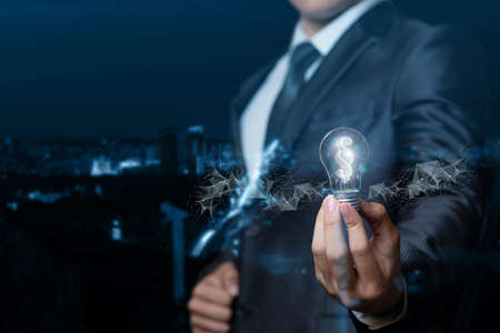 A lawyer or businessman showing light bulb burning inside the paragraph on blurred background.の写真素材