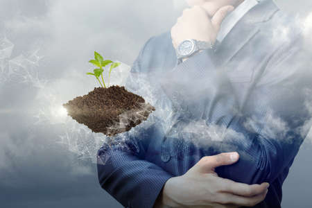 Sprout in the earth and a businessman on the background of the sky.