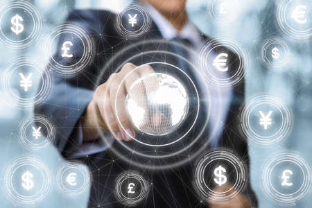 International currency market concept. Businessman on background with Globe and currency icons.