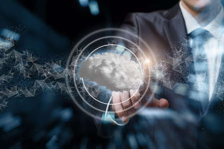 Businessmen clicks on the brain consisting of Cloud on a blurred background.
