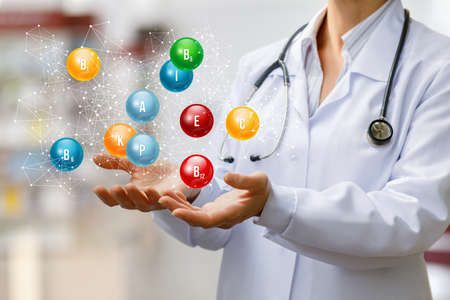 Doctor shows vitamins on a blurred background.