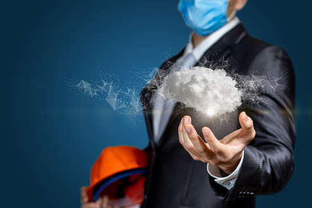 Civil engineer shows a brain consisting of clouds on a blue background.の写真素材