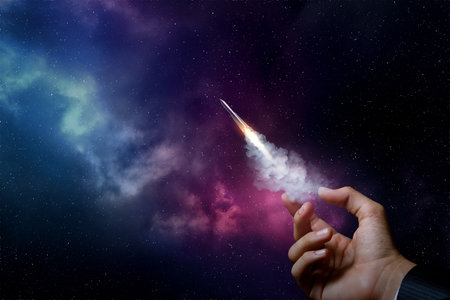 Startup concept and promotion. Hand launches a rocket on the background of outer space.