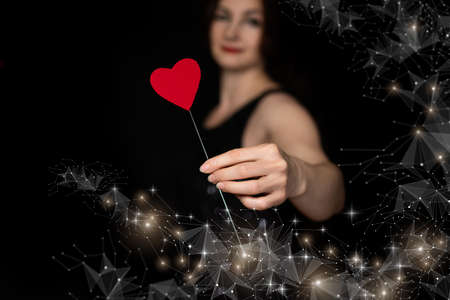 Woman shows valentine on the network on a black background.