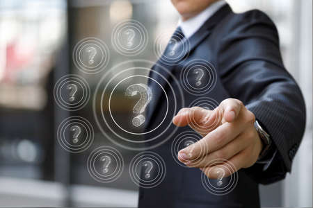 Business man works with questions on a virtual screen.の写真素材