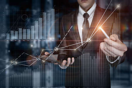 Business man analyzing financial growth graph on blurred background.の写真素材