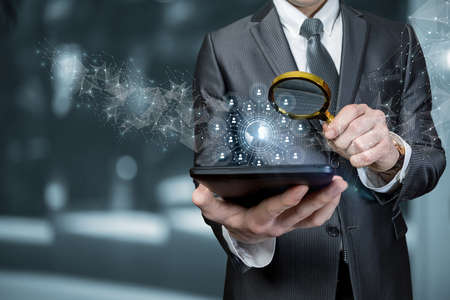 Business man searches the global business network on a mobile device.の写真素材