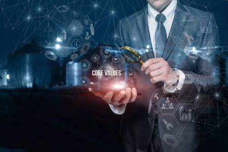 Business man analyzes the core values of the company us on a blurred background and a tablet.