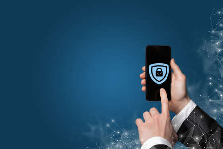 Business man set protection on phone on blue background.の写真素材
