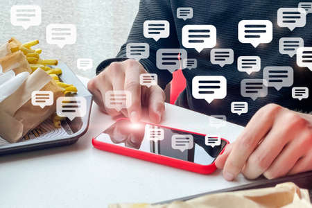 A man is texting message on the phone in a cafe.