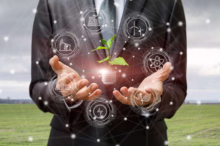 Business man shows the structure of energy production on a blurred background.