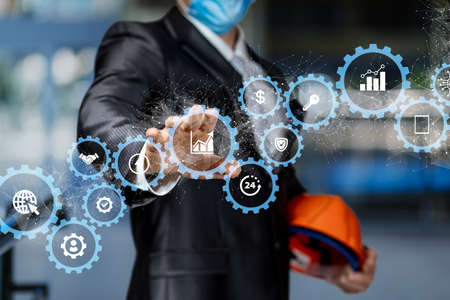 Engineer with helmet in hands works with mechanisms business management on blurred background.