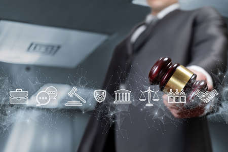 Young lawyer holding judge gavel on legal icons background.の写真素材