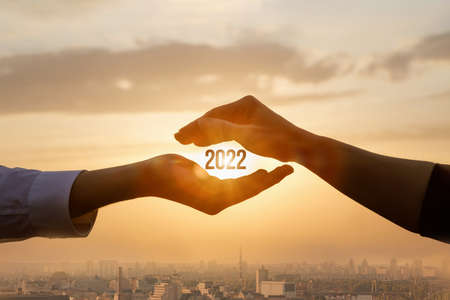 Hands protect the new 2022 against the background of the city.の写真素材