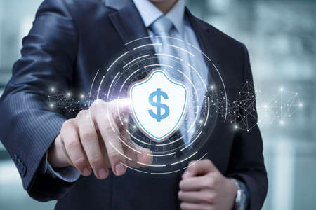 Financial security and protection concepts. Businessman clicks on a shield with a dollar.の写真素材
