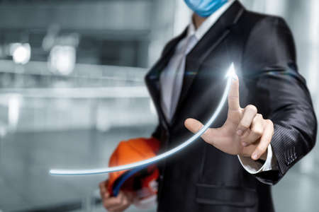 The concept of successful development of the construction business. Engineer architect clicks growth arrow.の写真素材